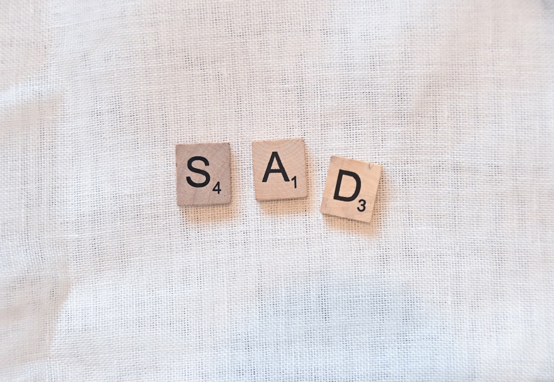 scrabble pieces spelling out sad — Foto por Nik na Unsplash