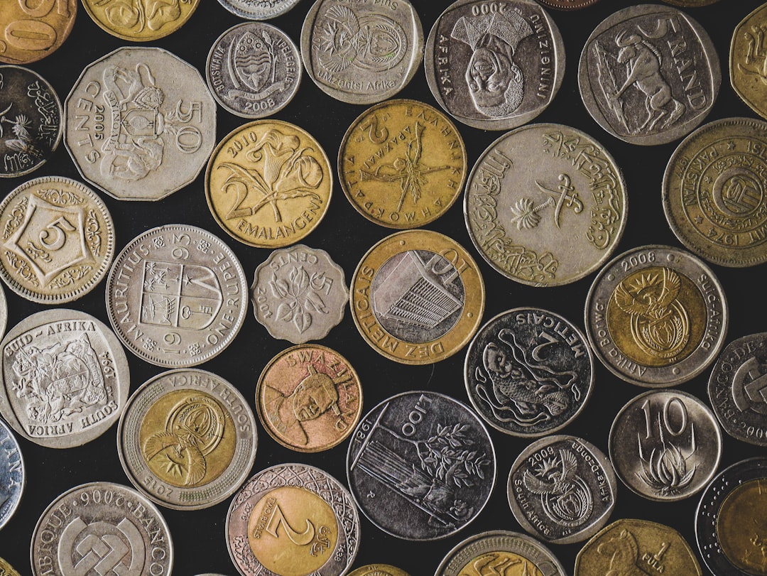 a pile of different types of coins — Foto por Ikrash Muhammad na Unsplash