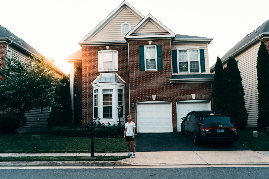 woman in white shirt and blue denim jeans walking on sidewalk near black car during daytime — Foto por Surasak Bandasak na Unsplash